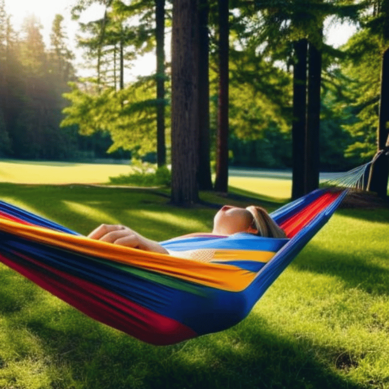 A person sleeping peacefully in a hammock surrounded by nature